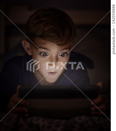 Tablet, surprise and boy child at night watch movie, film or show online for entertainment at home. Relax, dark and young kid streaming video on internet with digital technology in bedroom at house. Tablet, surprise and boy child at night watch movie, film or show online for entertainment at home. Relax, dark and young kid streaming video on internet with digital technology in bedroom at house. 142050986