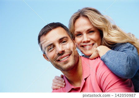 Couple, portrait and outdoor piggyback by blue sky, together and care for bonding in embrace. People, support and hug on holiday or vacation in nature, low angle and commitment on mockup space Couple, portrait and outdoor piggyback by blue sky, together and care for bonding in embrace. People, support and hug on holiday or vacation in nature, low angle and commitment on mockup space 142050987