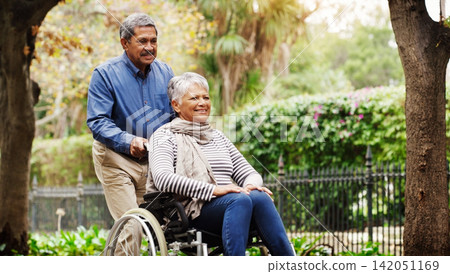 Senior man, woman and wheelchair in park by trees with love, smile and walking on vacation in summer. Elderly people, old couple and person with disability in nature for rehabilitation in retirement Senior man, woman and wheelchair in park by trees with love, smile and walking on vacation in summer. Elderly people, old couple and person with disability in nature for rehabilitation in retirement 142051169