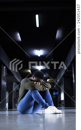 Woman, depression and sad on floor at train station for bad memory, ptsd or lonely on travel in night. African girl, person and cry at metro terminal with anxiety, lost or stress for future in subway Woman, depression and sad on floor at train station for bad memory, ptsd or lonely on travel in night. African girl, person and cry at metro terminal with anxiety, lost or stress for future in subway 142051437