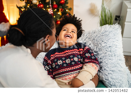 Mother and child sharing joyful Christmas holiday laughter Mother and child sharing joyful Christmas holiday laughter 142051482
