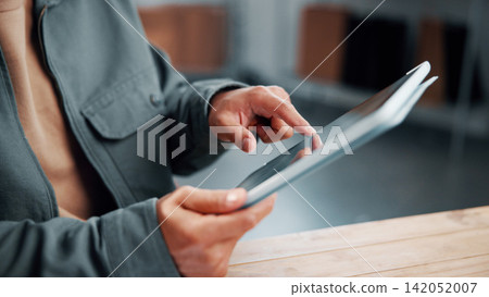 Hands, tablet and person in startup for ecommerce, order confirmation and track shipping. Logistics, technology and man in office with distribution email notification, schedule delivery or send quote Hands, tablet and person in startup for ecommerce, order confirmation and track shipping. Logistics, technology and man in office with distribution email notification, schedule delivery or send quote 142052007
