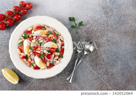 Turkish Piyaz white bean salad. Turkish cuisine on a gray background. Protein salad. Top view. Turkish Piyaz white bean salad. Turkish cuisine on a gray background. Protein salad. Top view. 142052064