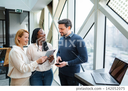 Diverse startup team collaborating using digital tablet and technology Diverse startup team collaborating using digital tablet and technology 142052075