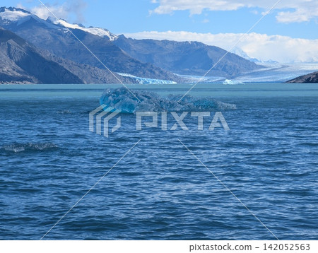 Small Blue Iceberg with Distant Glacier and Patagonian Mountains Small Blue Iceberg with Distant Glacier and Patagonian Mountains 142052563