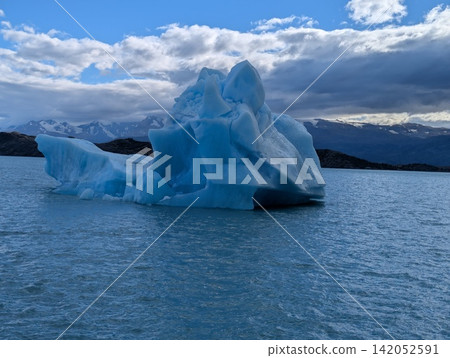 Intense Blue Iceberg Under Dark Patagonian Storm Clouds Intense Blue Iceberg Under Dark Patagonian Storm Clouds 142052591