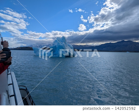 Tourist Photographing Blue Iceberg from Boat on Canal Upsala Tourist Photographing Blue Iceberg from Boat on Canal Upsala 142052592