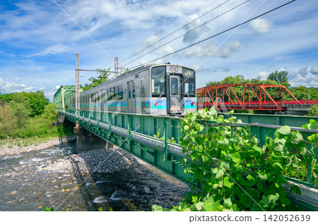 [Oito Line] Train crossing the Karasugawa River [Hodaka, Azumino City] 142052639