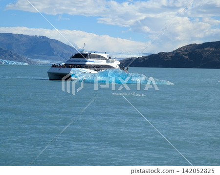 Canal Upsala, Argentina - March 11, 2026: Patagonia Infinity Catamaran Passes Blue Iceberg Canal Upsala, Argentina - March 11, 2026: Patagonia Infinity Catamaran Passes Blue Iceberg 142052825