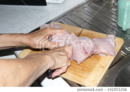 Preparing Chunks of Raw Poultry Meat for Grinding Preparing Chunks of Raw Poultry Meat for Grinding 142053206