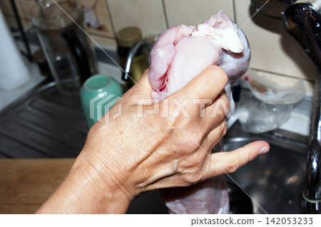 Hands Holding Washed Raw Poultry Meat Over Kitchen Sink Hands Holding Washed Raw Poultry Meat Over Kitchen Sink 142053233