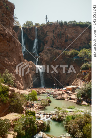 Tall Cascading Waterfall Surrounded by Cliffs Tall Cascading Waterfall Surrounded by Cliffs 142053242
