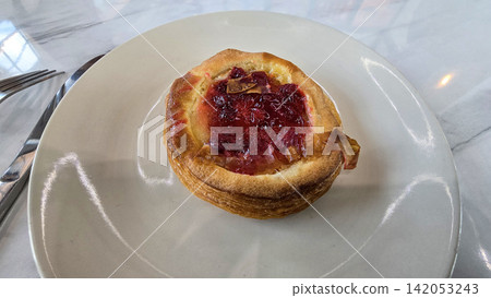 Golden flaky danish pastry jam tart puff served on a white plate with a fork on a marble table, ideal for breakfast, brunch, or dessert photography. Warm, homemade, sweet and appetizing bakery Golden flaky danish pastry jam tart puff served on a white plate with a fork on a marble table, ideal for breakfast, brunch, or dessert photography. Warm, homemade, sweet and appetizing bakery 142053243