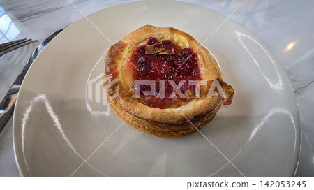 Golden flaky danish pastry jam tart puff served on a white plate with a fork on a marble table, ideal for breakfast, brunch, or dessert photography. Warm, homemade, sweet and appetizing bakery Golden flaky danish pastry jam tart puff served on a white plate with a fork on a marble table, ideal for breakfast, brunch, or dessert photography. Warm, homemade, sweet and appetizing bakery 142053245