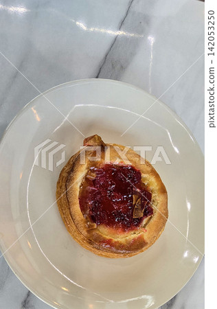 Golden flaky danish pastry jam tart puff served on a white plate with a fork on a marble table, ideal for breakfast, brunch, or dessert photography. Warm, homemade, sweet and appetizing bakery Golden flaky danish pastry jam tart puff served on a white plate with a fork on a marble table, ideal for breakfast, brunch, or dessert photography. Warm, homemade, sweet and appetizing bakery 142053250
