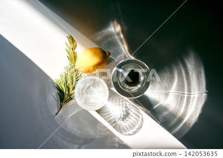 Refreshing water with lemon and rosemary in sunlight 142053635