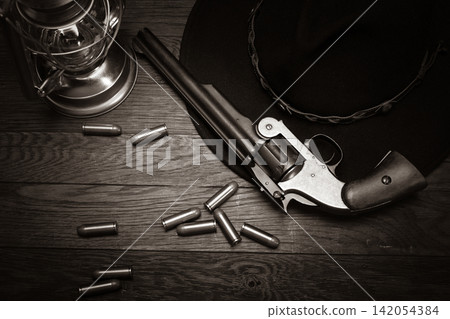 Antique Revolver with Ammunition, Cowboy Hat and Lantern on Wooden Table Antique Revolver with Ammunition, Cowboy Hat and Lantern on Wooden Table 142054384