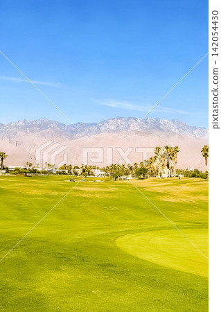 A lush California golf course that stands out against the La Quinta mountain range and blue sky. A lush California golf course that stands out against the La Quinta mountain range and blue sky. 142054430