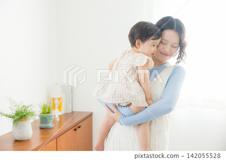 A mother holding her one-year-old daughter. A mother holding her one-year-old daughter. 142055528