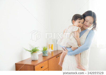 A mother holding her one-year-old daughter. A mother holding her one-year-old daughter. 142055529