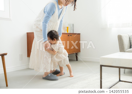 一位母親抱著她一歲的女兒。 一位母親抱著她一歲的女兒。 142055535