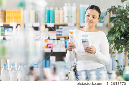 Asian woman choosing cream in pharmacy Asian woman choosing cream in pharmacy 142055770