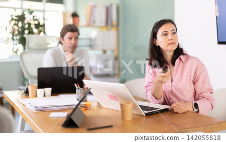 Manager gives presentation using remote control Manager gives presentation using remote control 142055818