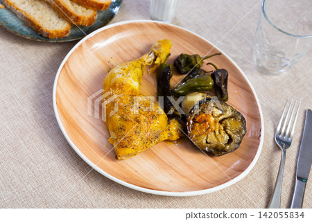 Baked or fried chicken thigh with vegetables, whole peppers and eggplant Baked or fried chicken thigh with vegetables, whole peppers and eggplant 142055834
