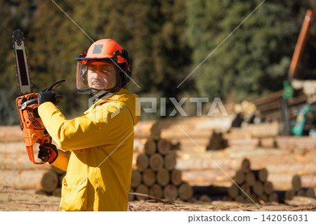 A man with a chainsaw A man with a chainsaw 142056031