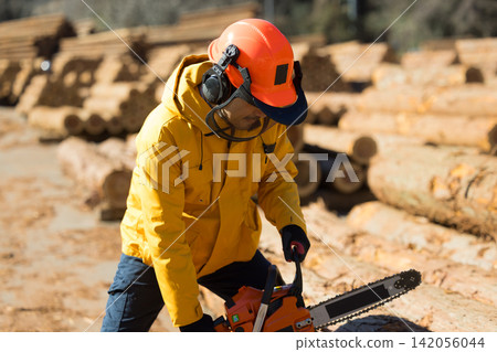 A man with a chainsaw A man with a chainsaw 142056044
