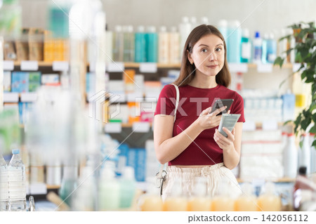 Young woman scanning qr code of cream Young woman scanning qr code of cream 142056112