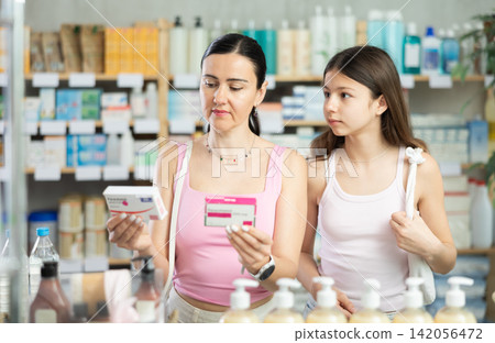 Mom and daughter customer choosing paracetamol in drugstore Mom and daughter customer choosing paracetamol in drugstore 142056472
