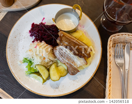 Pieces of pork with pickled cucumbers, sauerkraut and beets Pieces of pork with pickled cucumbers, sauerkraut and beets 142056518