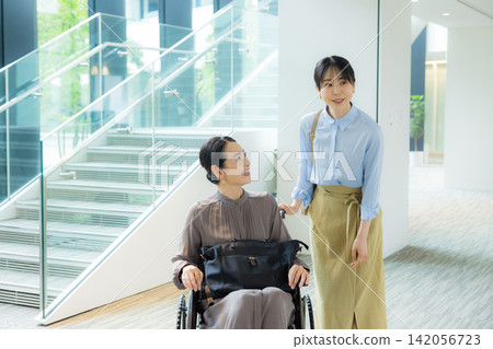 一位家長帶著孩子外出,孩子盛裝打扮,其中一人坐在輪椅上。 一位家長帶著孩子外出,孩子盛裝打扮,其中一人坐在輪椅上。 142056723