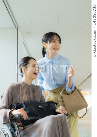 一位家長帶著孩子外出，孩子盛裝打扮，其中一人坐在輪椅上。 142056730