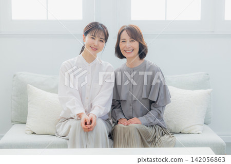 Senior and middle-aged women talking on a sofa Senior and middle-aged women talking on a sofa 142056863