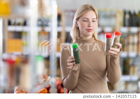 Young woman choosing spices and seasonings in grocery Young woman choosing spices and seasonings in grocery 142057115