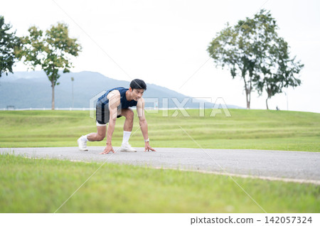 Athletic Asian Man Starting Outdoor Sprint Athletic Asian Man Starting Outdoor Sprint 142057324