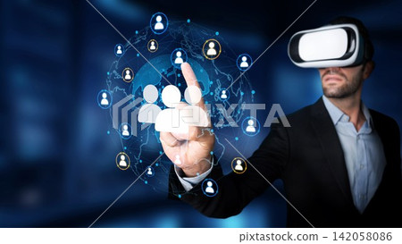 Businessman Wearing Virtual Reality Headset Interacting with Digital Network and User Connections in Futuristic Office Environment. Entropy Businessman Wearing Virtual Reality Headset Interacting with Digital Network and User Connections in Futuristic Office Environment. Entropy 142058086