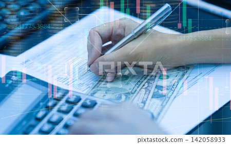 Tax season concept. Woman hand filing US income tax return form for tax payment. Money and financial. Paperwork for paying taxes. Tax planning and consulting service business. Stock market graph. Tax season concept. Woman hand filing US income tax return form for tax payment. Money and financial. Paperwork for paying taxes. Tax planning and consulting service business. Stock market graph. 142058933