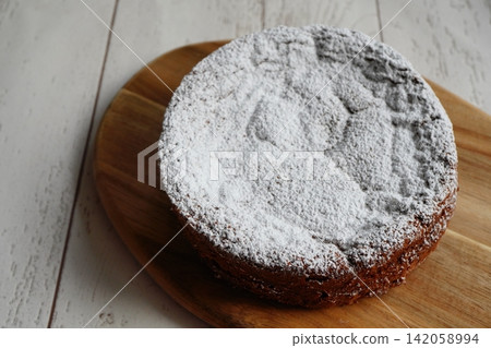 A whole chocolate cake lightly dusted with powdered sugar. A whole chocolate cake lightly dusted with powdered sugar. 142058994