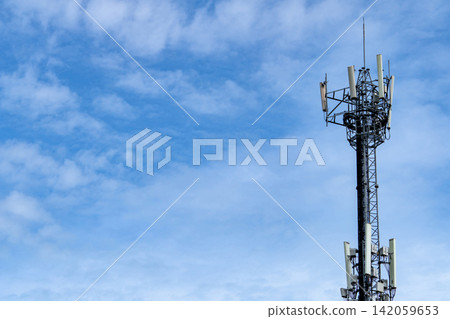 Telecommunication tower with blue sky and white clouds background. Antenna on blue sky. Radio and satellite pole. Communication technology. Telecommunication industry. Mobile or telecom 4g network. Telecommunication tower with blue sky and white clouds background. Antenna on blue sky. Radio and satellite pole. Communication technology. Telecommunication industry. Mobile or telecom 4g network. 142059653