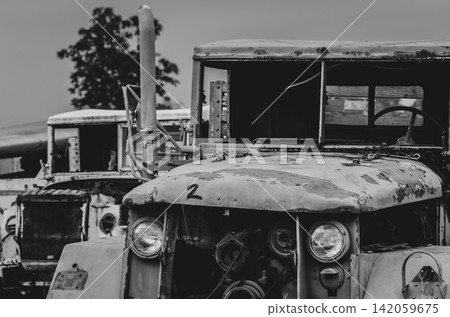 Abandoned rusty military trucks parked in storage yard with visible corrosion and aging equipment. Fleet depreciation, industrial maintenance, transportation logistics, recycling and economic decline. Abandoned rusty military trucks parked in storage yard with visible corrosion and aging equipment. Fleet depreciation, industrial maintenance, transportation logistics, recycling and economic decline. 142059675