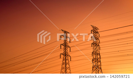 Silhouette of high voltage electricity transmission towers connected by overhead power lines during vibrant orange sunset. National power grid infrastructure, engineering and energy security. Silhouette of high voltage electricity transmission towers connected by overhead power lines during vibrant orange sunset. National power grid infrastructure, engineering and energy security. 142059721