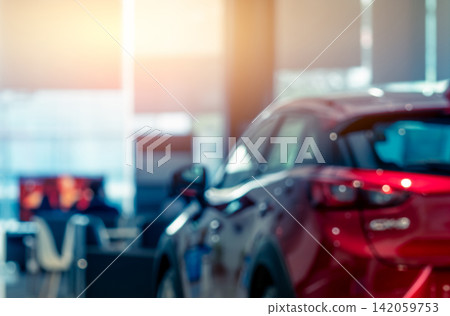 Blurred luxury red automobile inside a modern car dealership showroom. Automotive retail background. Vehicle sales, electric mobility, leasing, insurance, transportation business. Automobile industry. Blurred luxury red automobile inside a modern car dealership showroom. Automotive retail background. Vehicle sales, electric mobility, leasing, insurance, transportation business. Automobile industry. 142059753