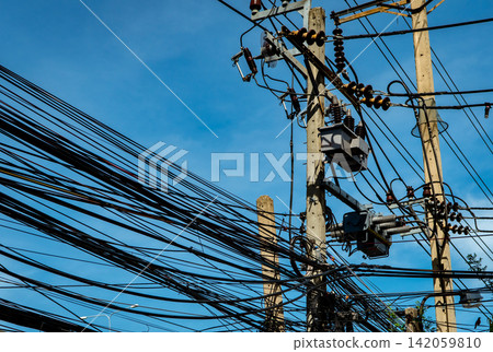 Three-phase electric power for transfer power by electrical grids. Electric power for support manufacturing industry. High voltage electric poles with wire lines and cable lines against blue sky Three-phase electric power for transfer power by electrical grids. Electric power for support manufacturing industry. High voltage electric poles with wire lines and cable lines against blue sky 142059810
