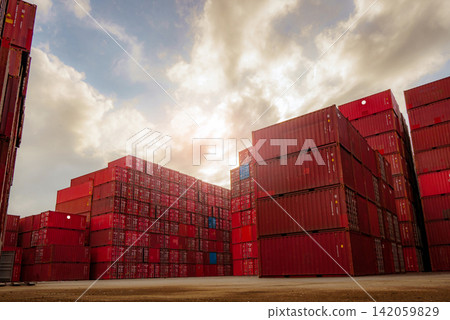 Stacked shipping containers at international cargo terminal with cloudscape, global logistics hub supporting import export operations, freight transportation and worldwide supply chain industry. Stacked shipping containers at international cargo terminal with cloudscape, global logistics hub supporting import export operations, freight transportation and worldwide supply chain industry. 142059829