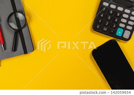 Financial planning tools on a yellow surface with a calculator Financial planning tools on a yellow surface with a calculator 142059934