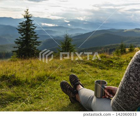 Relaxing in the Carpathian Mountains with a drink in hand Relaxing in the Carpathian Mountains with a drink in hand 142060033