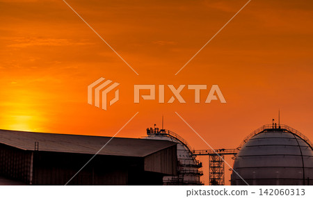 Liquefied natural gas storage tanks at a modern petroleum refinery beneath sunset sky, industrial energy infrastructure. Global fuel storage, logistics and supply security. Petroleum engineering. Liquefied natural gas storage tanks at a modern petroleum refinery beneath sunset sky, industrial energy infrastructure. Global fuel storage, logistics and supply security. Petroleum engineering. 142060313